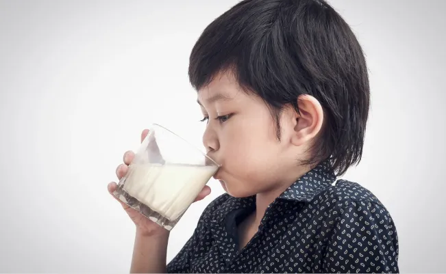 Close-up of young boy drinking a glass of milk